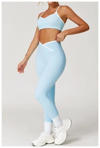 Detail van de yoga-legging met hoge taille, wit V-vormig crossover-ontwerp en blauwe stof