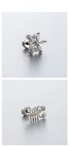 Macro view of silver scorpion and flower stud earrings with shimmering zircon inlays