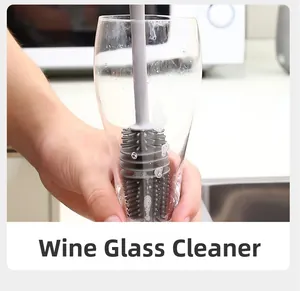 Detail of grey silicone long handle brush cleaning a tall glass in a kitchen setting