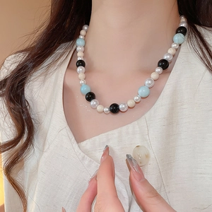 Detail of multi-colored glass beads and pearls necklace on model neckline