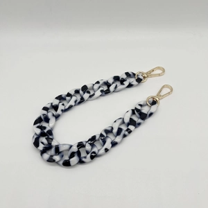 Detail of acrylic resin chain with black and white marble pattern and gold lobster clasps