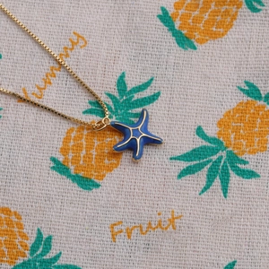 Fashionable gold plated necklace featuring a blue starfish pendant on a gold box chain