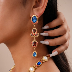 Close-up of vintage gold multi-layer necklace with blue gems and red enamel water drop pendants