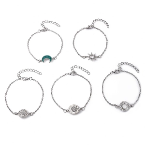 Detailed view of five-piece silver bracelet set with turquoise moon and sun charms