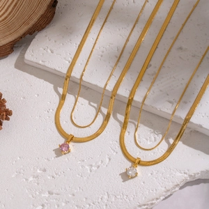 Close-up of double-layered gold snake chains with pink and white zircon stone pendants