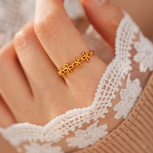 Gros plan d'une bague fleur vintage en or avec manchette en dentelle et fond en tricot