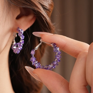 Detailed close-up of a model wearing a purple cubic zirconia hoop earring in vintage style