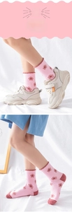 Detailed view of pink floral cotton socks for kids featuring decorative frill cuffs
