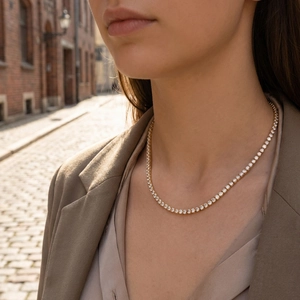 Classic gold plated tennis necklace with shimmering zircons worn on model in natural light
