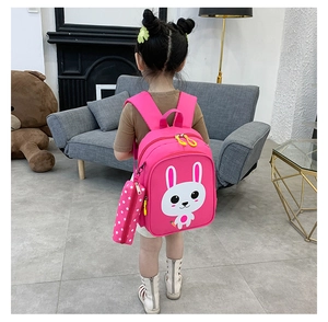 Pink toddler backpack with cartoon bunny print and matching pencil case on a child