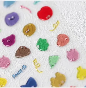 Macro detail of 3D jelly nail stickers with colorful irregular shapes and cartoon eyes