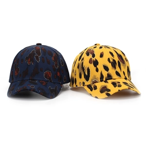 Detail of navy blue and yellow leopard print baseball caps showing twill cotton texture