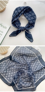 Detail of blue and white floral cotton linen scarf with elegant folding and fabric texture