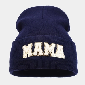 Close-up of MAMA chenille letter patch on navy blue knitted beanie for women