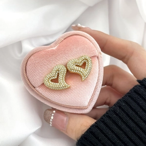 Detail of gold heart earrings with white zircons in a pink velvet jewelry gift box