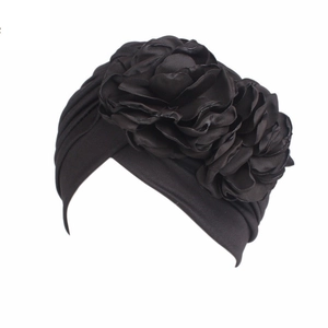 Elastic black turban hat for women featuring a large decorative fabric flower on the side