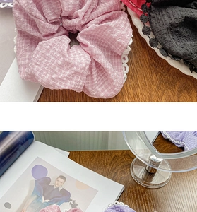 Detail of colorful lace scrunchies in pink, black and purple on a wooden table