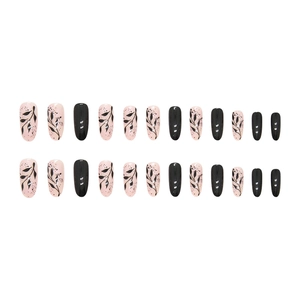 Oval press-on nails set with black silhouette leaf patterns and glossy black finish