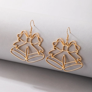 Détail de boucles d'oreilles cloches de Noël ajourées dorées avec nœud sur présentoir