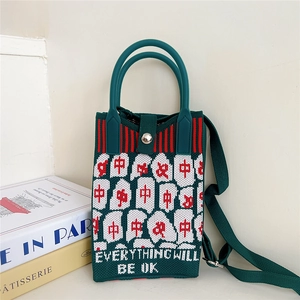 Detail of green knitted crossbody bag with white cloud and everything will be ok text