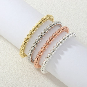 Detailed view of elastic metal bead bracelets in gold, silver, and rose gold finishes