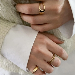 Close-up of three-piece gold ring set featuring wide band and twisted rope designs