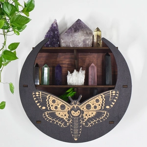 Detail view of a crescent moon wooden shelf featuring a carved moth and crystal compartments