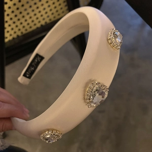 Detail of handmade cream satin sponge headband with sparkling rhinestone hearts