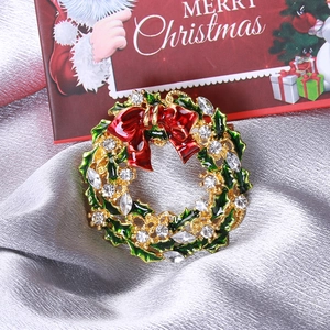 Vue macro d'une broche couronne de Noël avec strass colorés sur tissu satiné argent