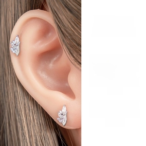 Detailed view of a silver leaf-shaped ear stud featuring sparkling cubic zirconia stones