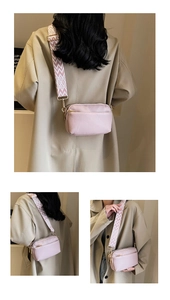 Pink PU leather crossbody bag featuring a wide geometric fabric strap and gold hardware