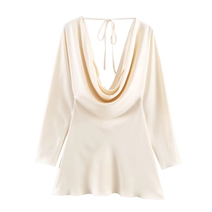Detail of elegant champagne satin dress featuring a cowl neck and smooth silk texture
