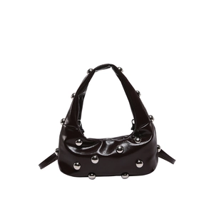 Chic dark patent leather underarm bag with silver spherical rivets and curved silhouette