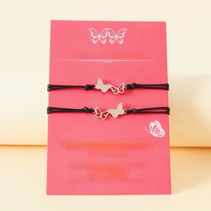 Détail de bracelets papillon tressés mère-fille sur une carte-cadeau rose