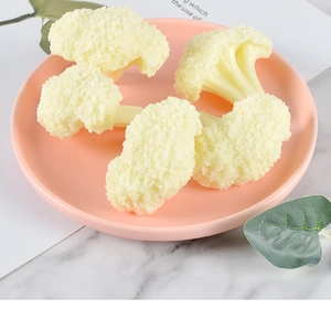 Detailed view of four realistic PVC cauliflower food models on a decorative pink plate