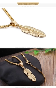 Macro detail of golden stainless steel feather pendant with textured leaf patterns