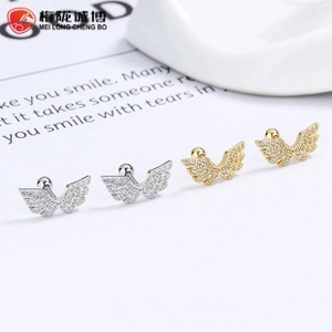 Detailed close-up of wing earrings with white zircon inlays and secure screw backings
