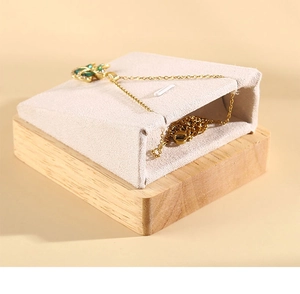 Detail of wooden jewelry display stand with beige velvet cushion for necklaces