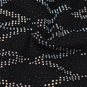 Detail of black knit fabric featuring shimmering rhinestone patterns in wave lines