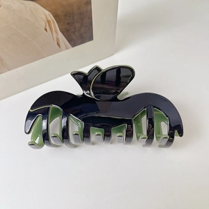 Dettaglio molletta per capelli a tulipano in acetato nero con interno verde chiaro