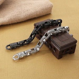 Macro detail of retro engraved stainless steel square link bracelets in silver and black