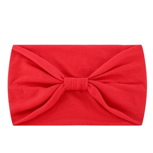 Detailed close-up of a red elastic yoga headband featuring a classic central bow knot