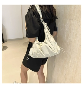 Detailed view of cream nylon drawstring crossbody bag with ruffled strap for women