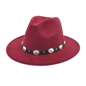 Detail of burgundy fedora hat with black leather band and silver metal embossed studs