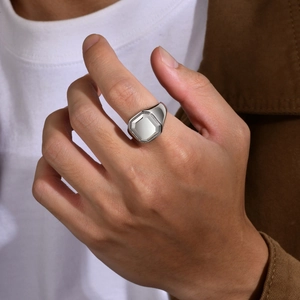 Classic silver signet ring with an octagonal face on male hand in natural side light