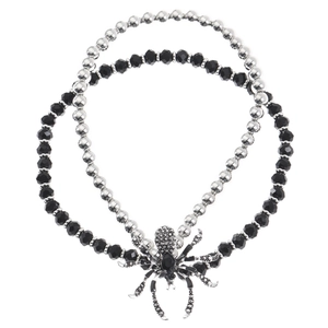 Macro detail of gothic silver spider pendant with black crystals on bead chain necklace
