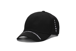 Detail of white embroidery 'Heart is always a good listener' on a black cotton baseball cap