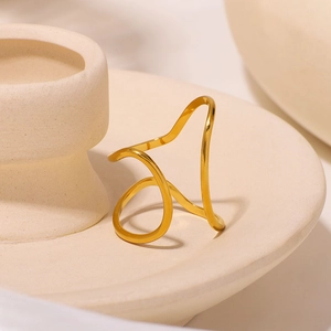 Anello minimalista in acciaio inossidabile dorato a forma di onda su vassoio crema
