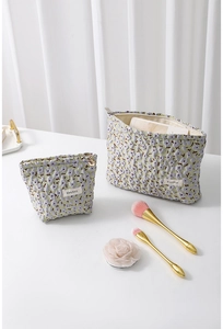 Detailansicht von Jacquard-Kosmetiktaschen mit Blumenmuster und goldenen Reißverschlüssen