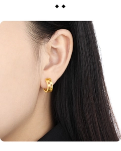 Close-up of matte gold geometric hollow square earrings on a model's ear lobe